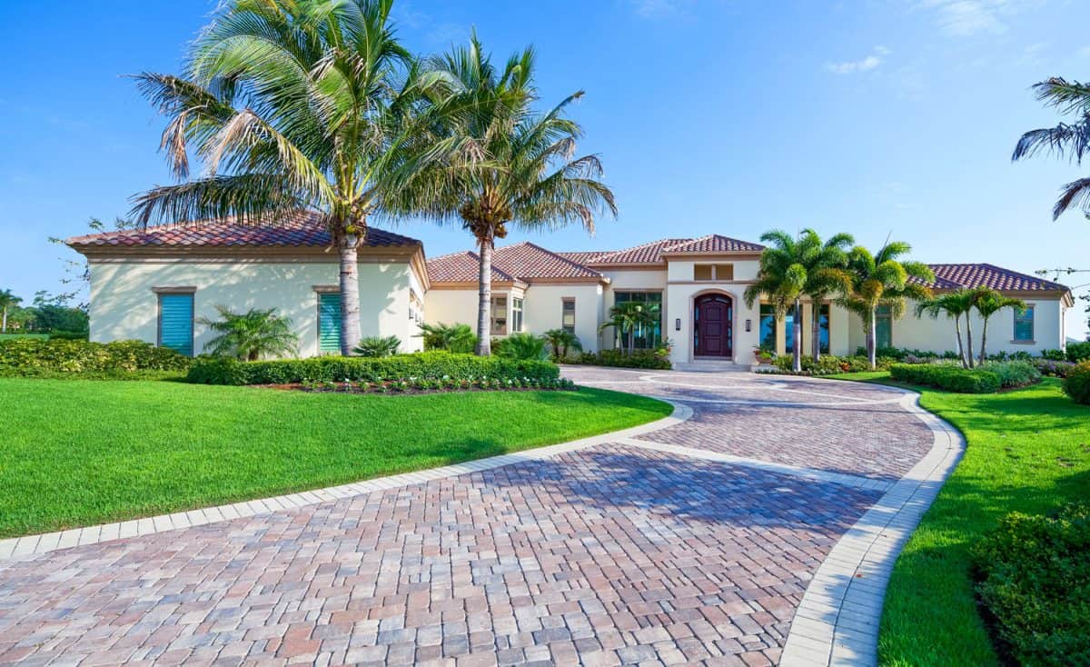A paver driveway leads to a beautiful estate home in Florida.