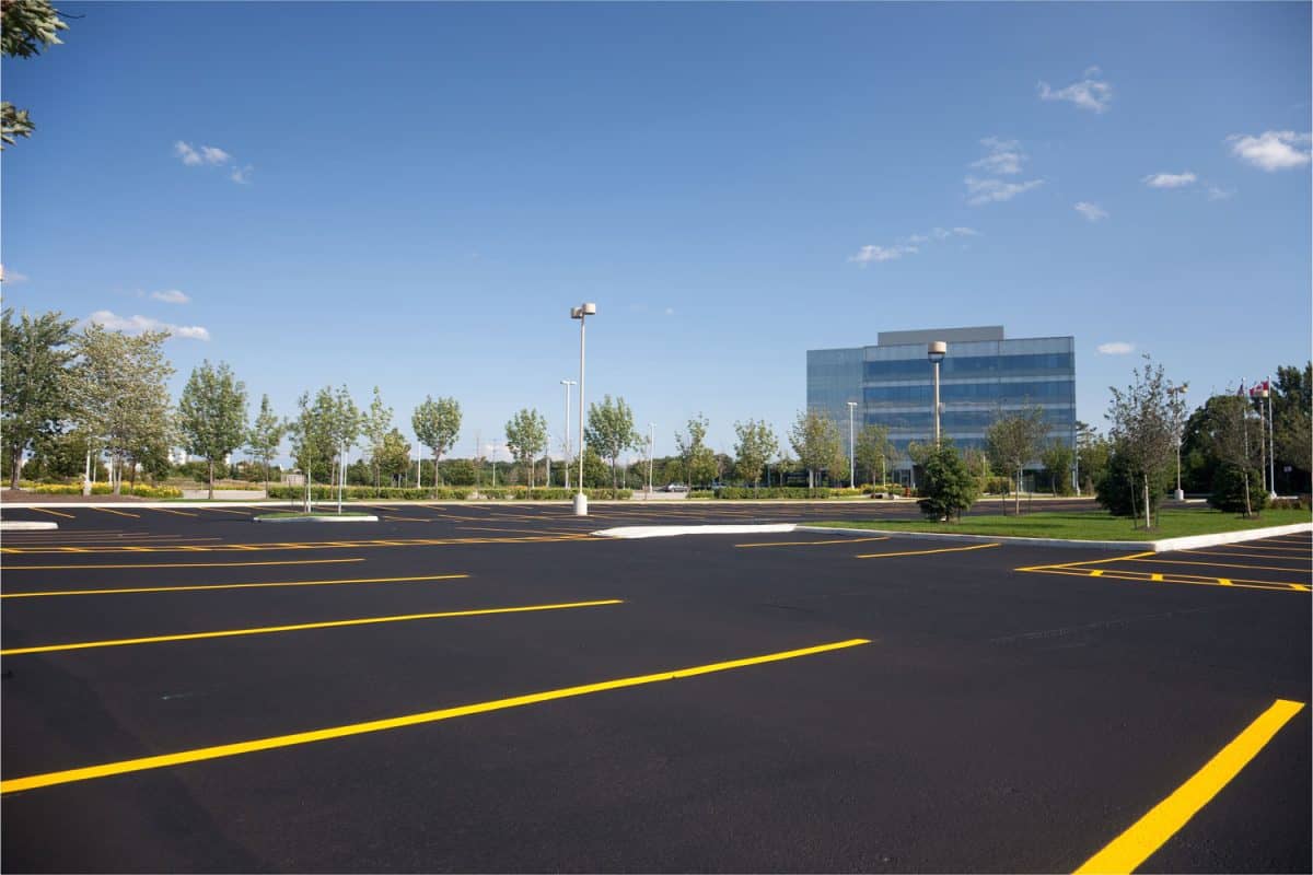 A picture of an empty parking lot with a building in the background.