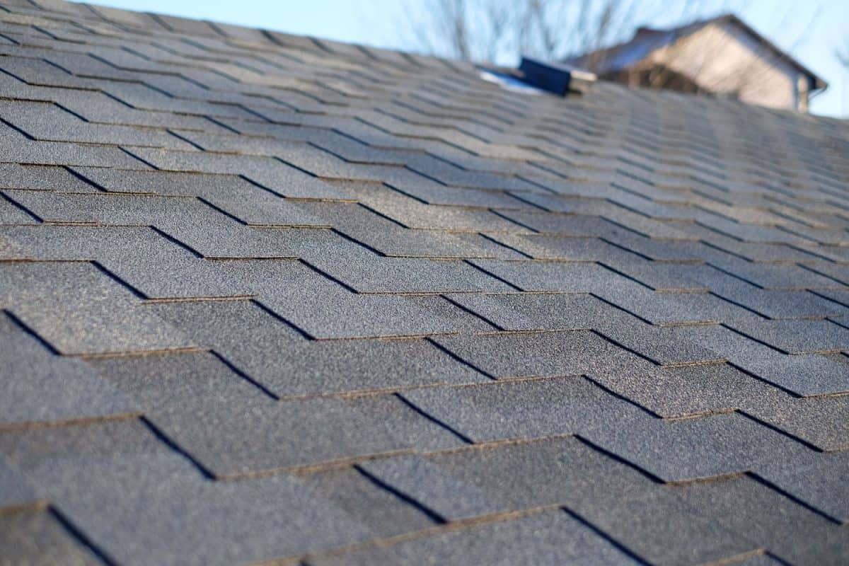 Bitumen tile roof. Roof Shingles - Roofing. Close up view on Asphalt Roofing Shingles
