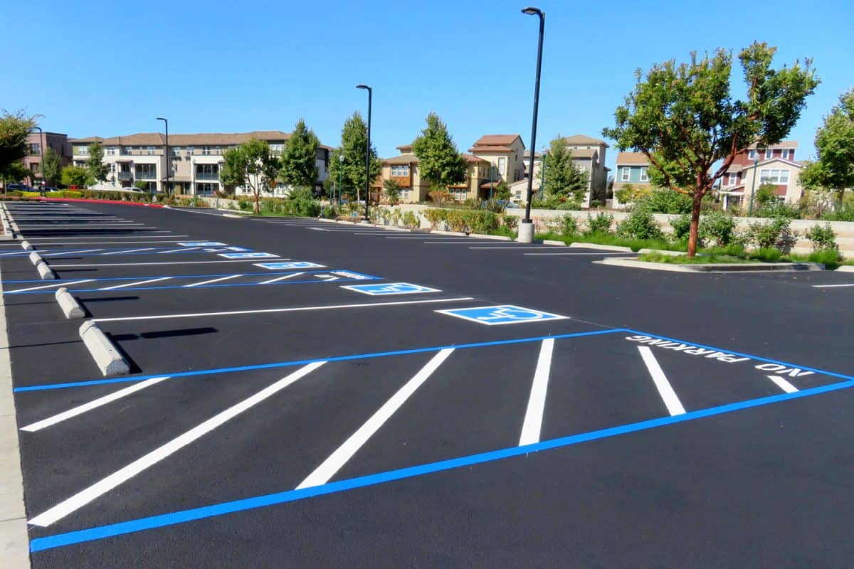 Freshly resurfaced and repainted handicap parking space in a parking lot, Can Asphalt Be Painted? [And How To]
