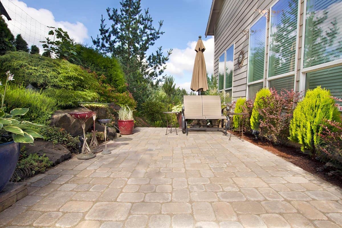 Garden backyard paver patio with chairs umbrella and decoration
