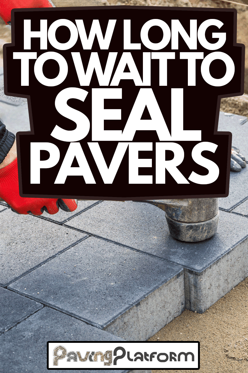 How Long to Wait to Seal Pavers, Hands of worker installing concrete paver blocks with rubber hammer