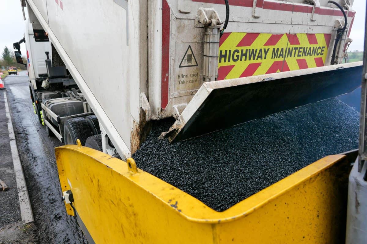 A dump truck carrying asphalt to feed the asphalt paver