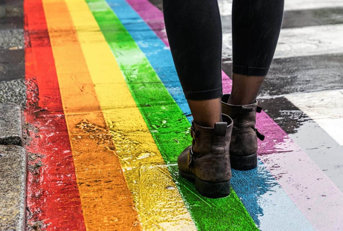 Legs walking on Gay rainbow crosswalk