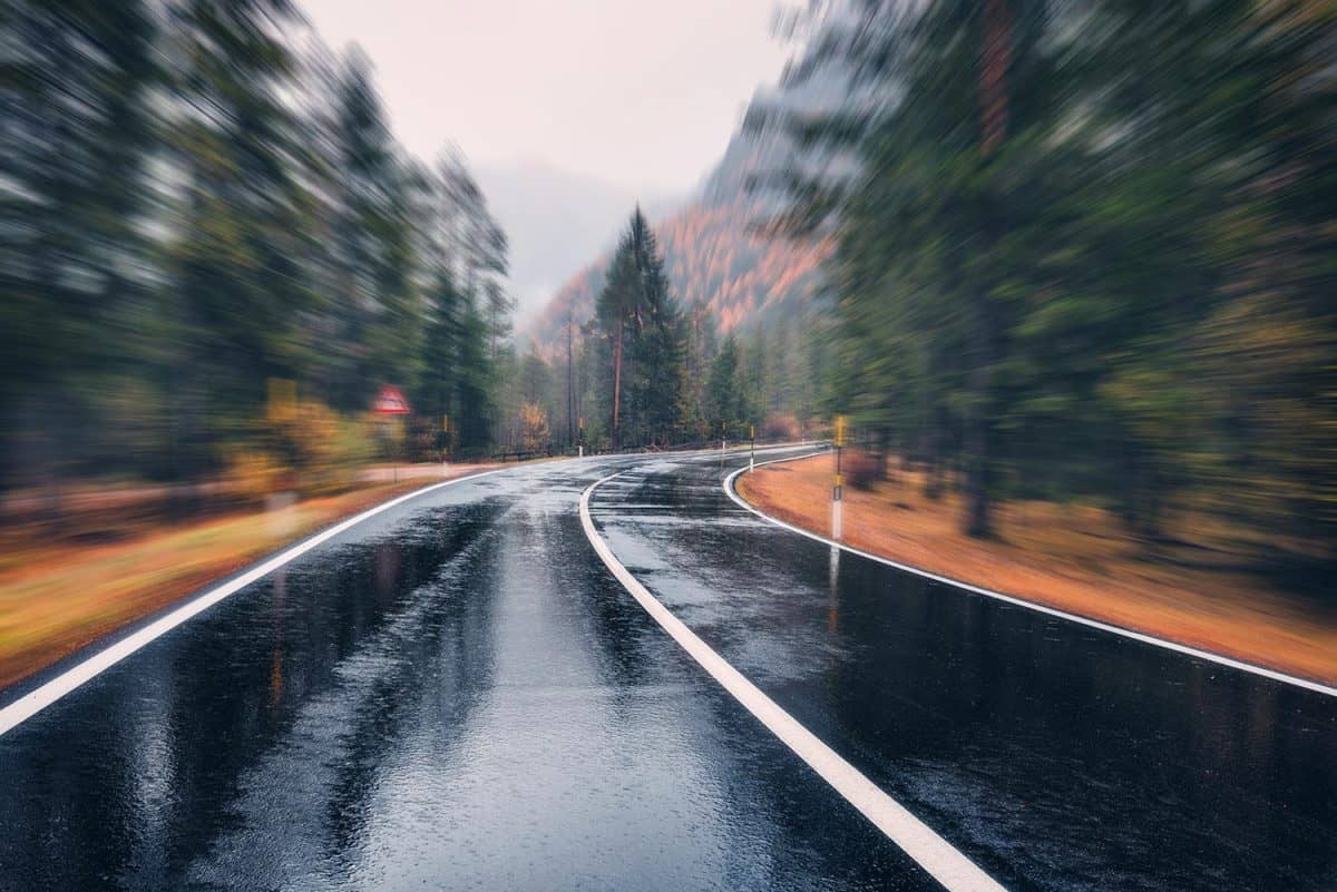 Perfect asphalt mountain road in overcast rainy day with blurred background