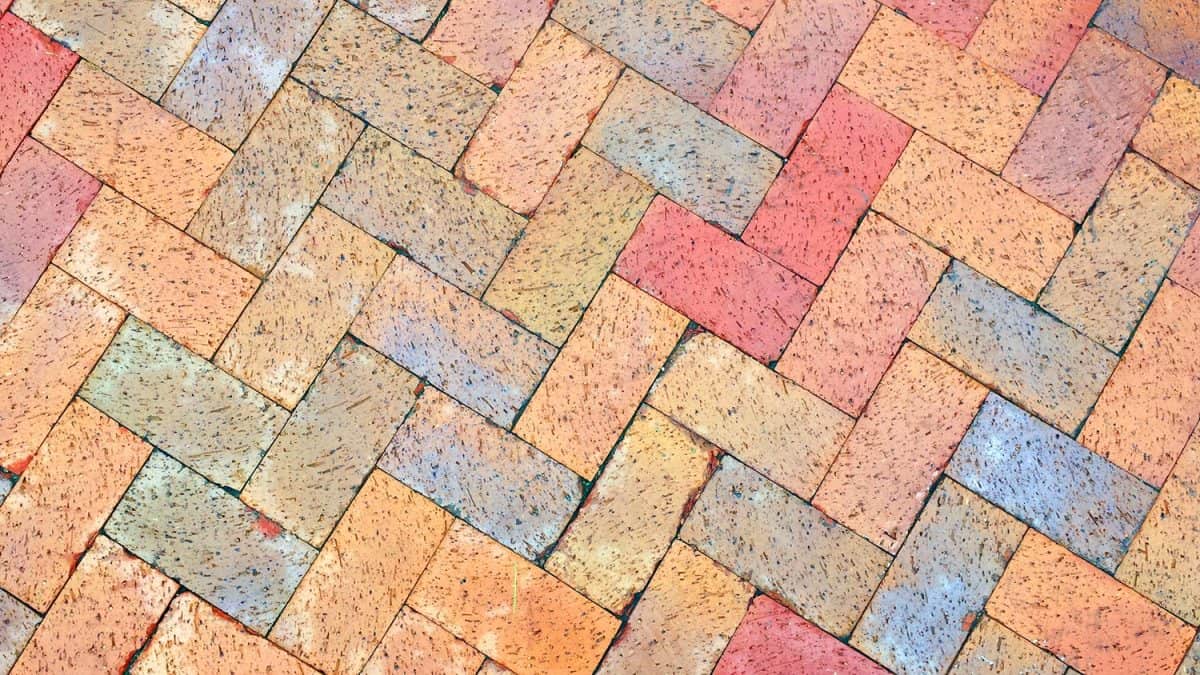 Texture of colorful brick pavers in Herringbone pattern