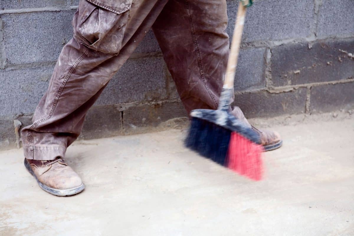 Worker sweeping the construction site floor