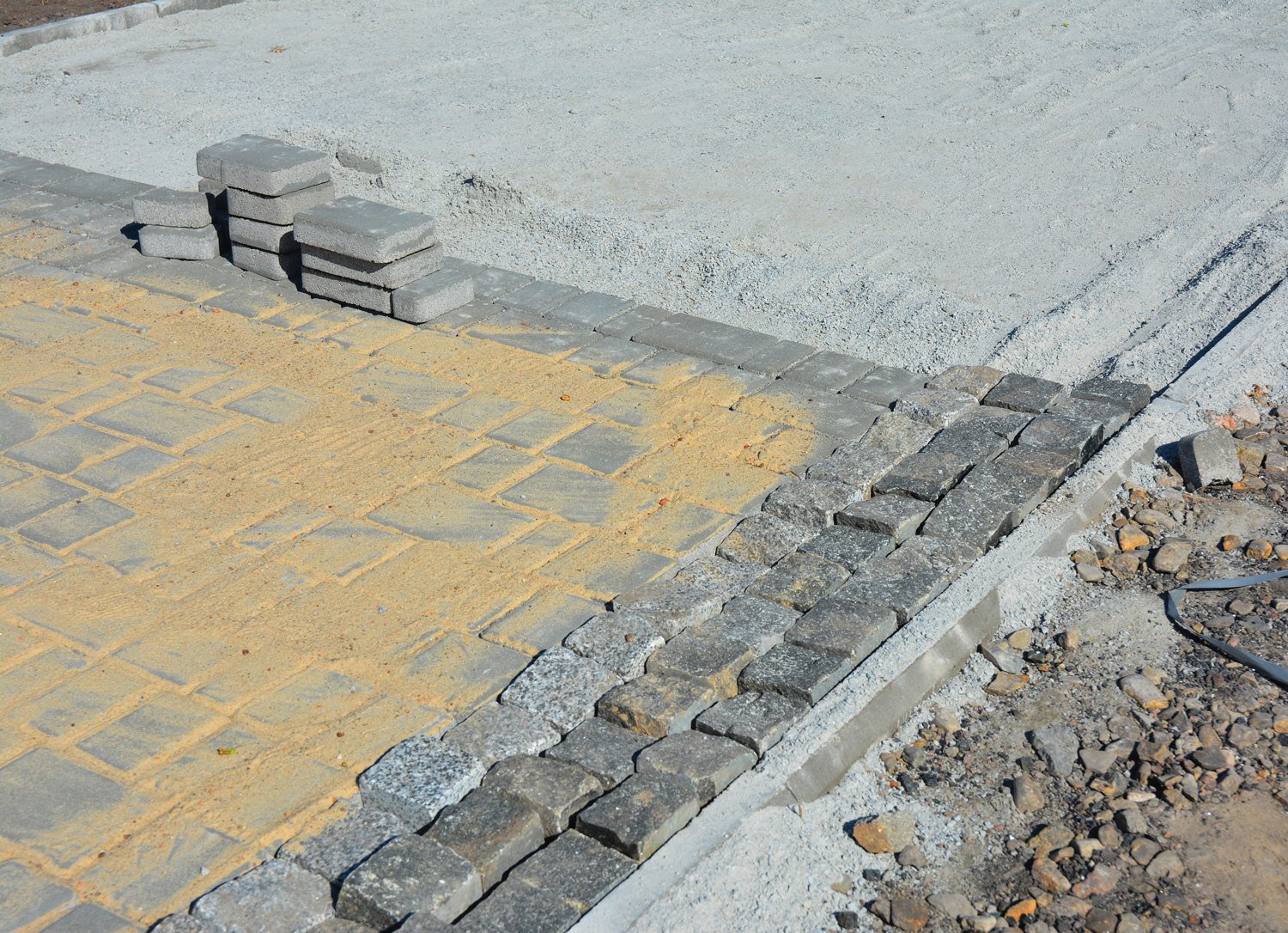 A close-up of a block footpath paving, paver edging and pavers installation, building a paver walkway.