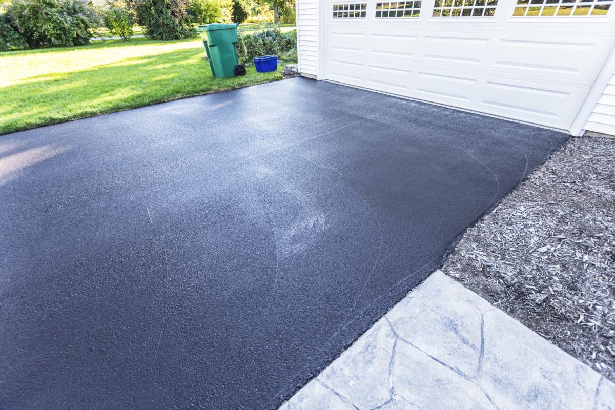 A fresh blacktop resealing job just finished on this asphalt driveway in a suburban residential district - What Is The Difference Between Tarmac And Asphalt