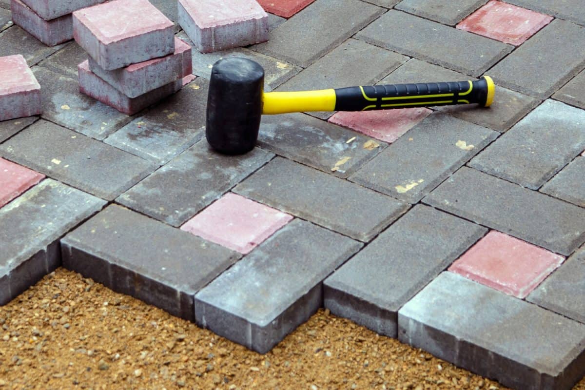 A rubber mallet on top of colored brick pavers