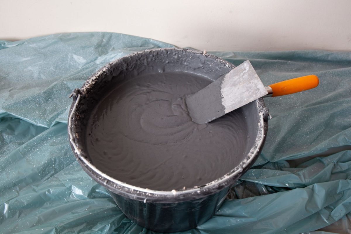A small bucket of plaster with trowel
