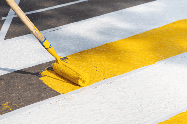 Application Of Road Markings For Pedestrians With Bright Yellow And White Paints. How To Clean Asphalt Surface Before Painting