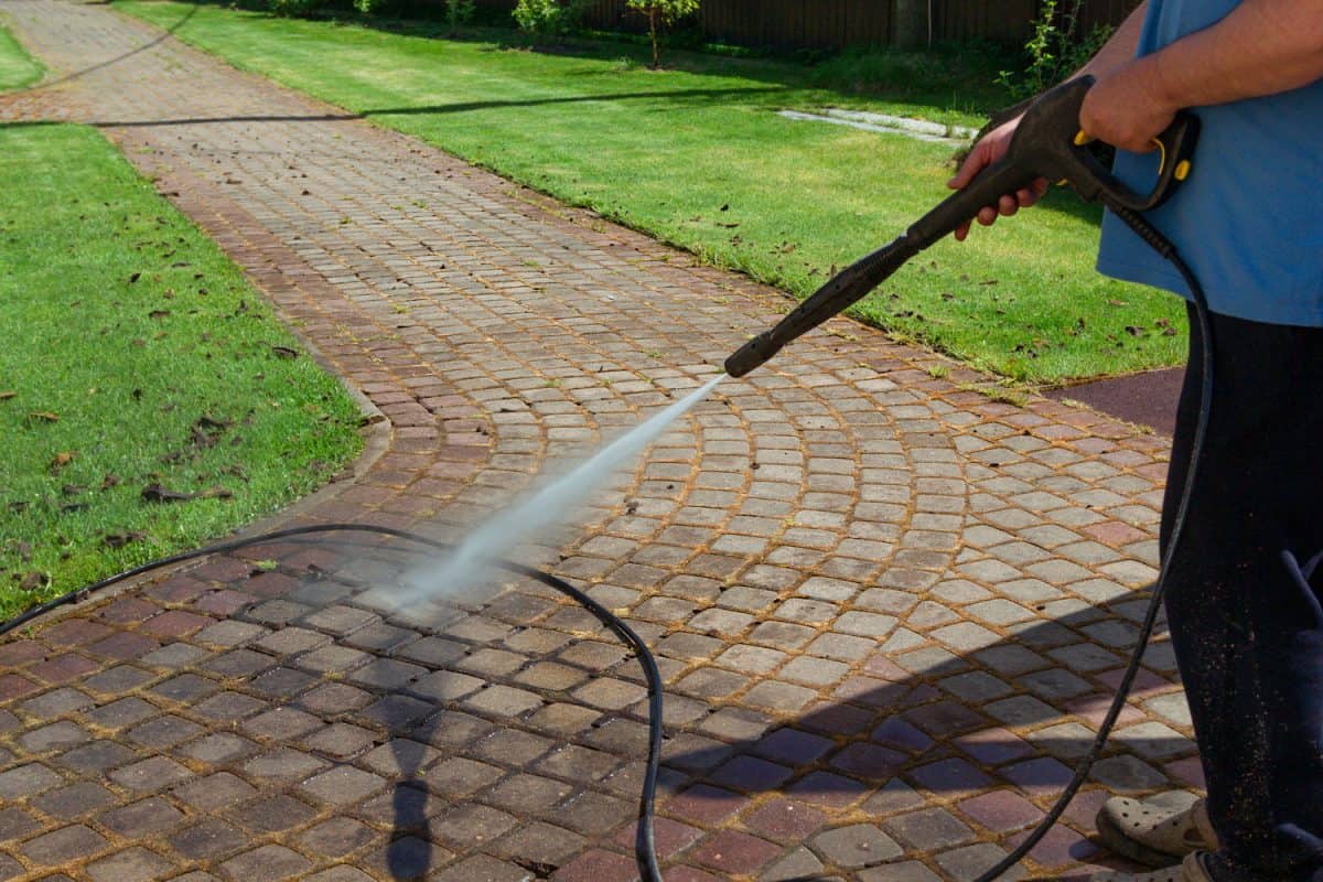 Cleaning pavers using a high powered pressure sprayer