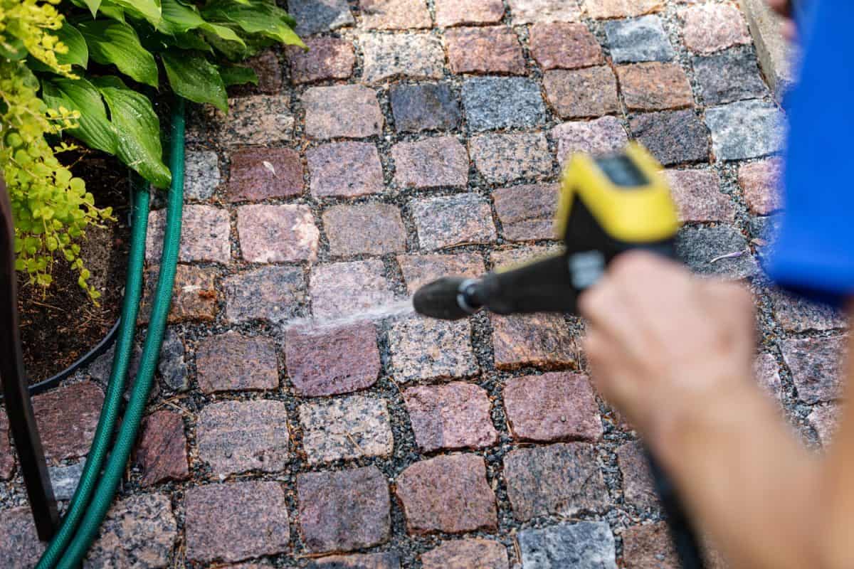 Cleaning the pavement using a power washer