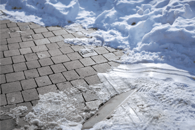 Close-up on tiled pavement covered with ice and snow. How To Prevent Frost Heave Damage On Pavers