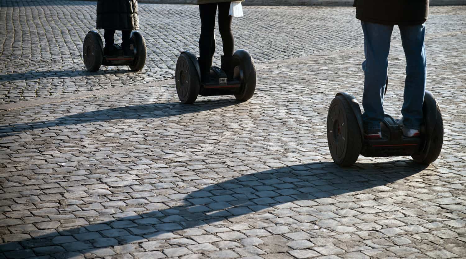 Human legs on the wheels in the street.