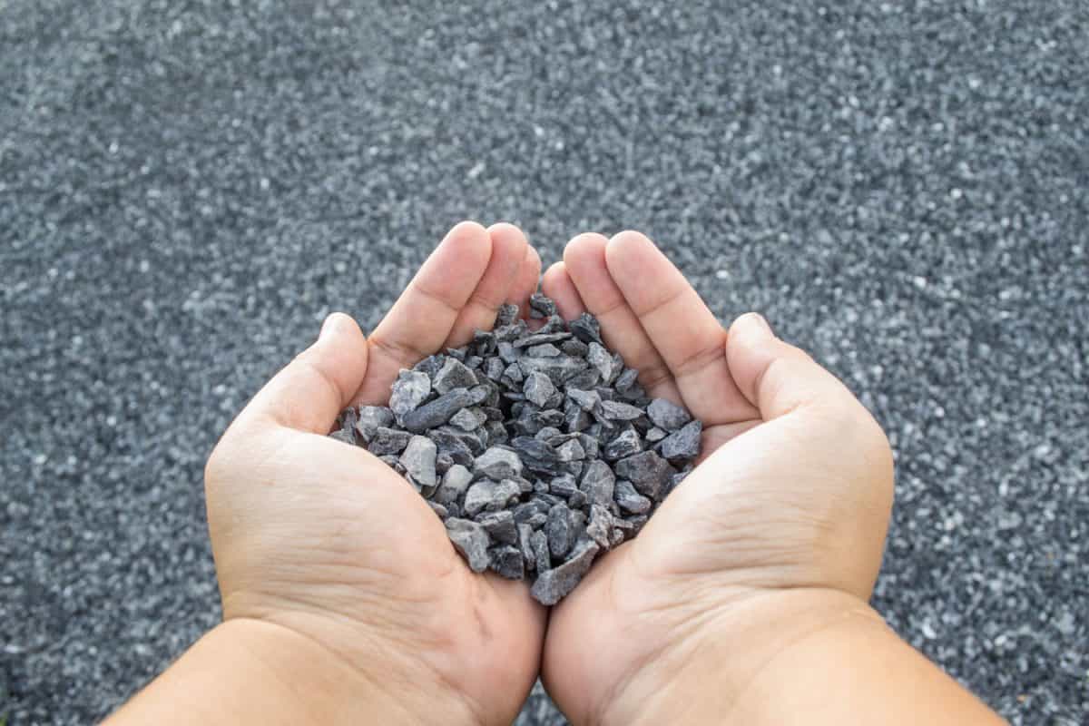 Man holding a handful of crushed gravel