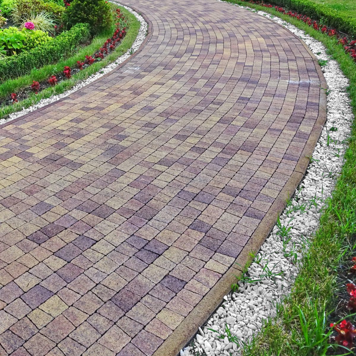 Modern Ornamental Garden Landscape With Tiled Colorful Mosaic Cobblestone Paving. Marble White Gravel Along Walkway