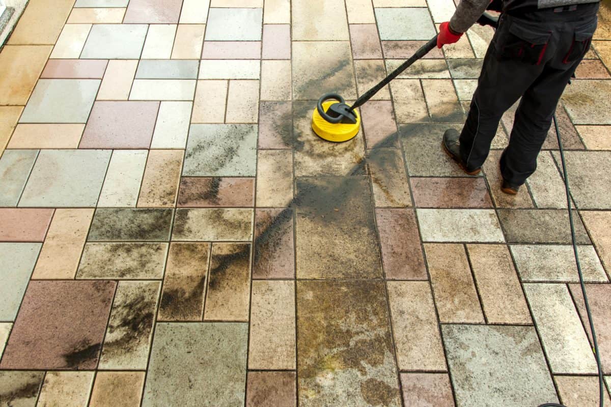 Person worker cleaning the outdoors floor.

