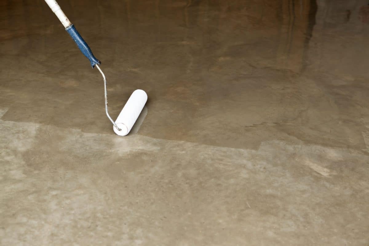 Polishing the concrete using a paint roller. Epoxy coating on flooring