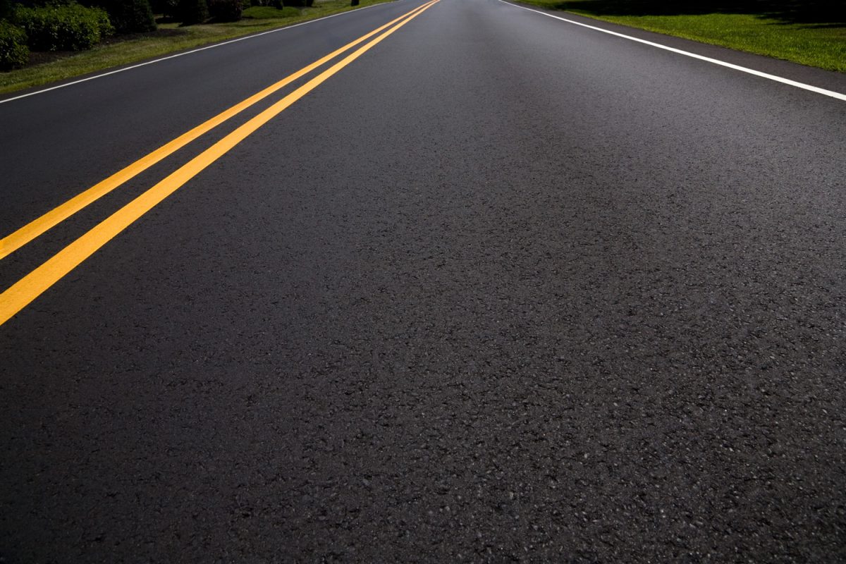 Right Lane of a Freshly Paved Asphalt Road Diminishing Perspective