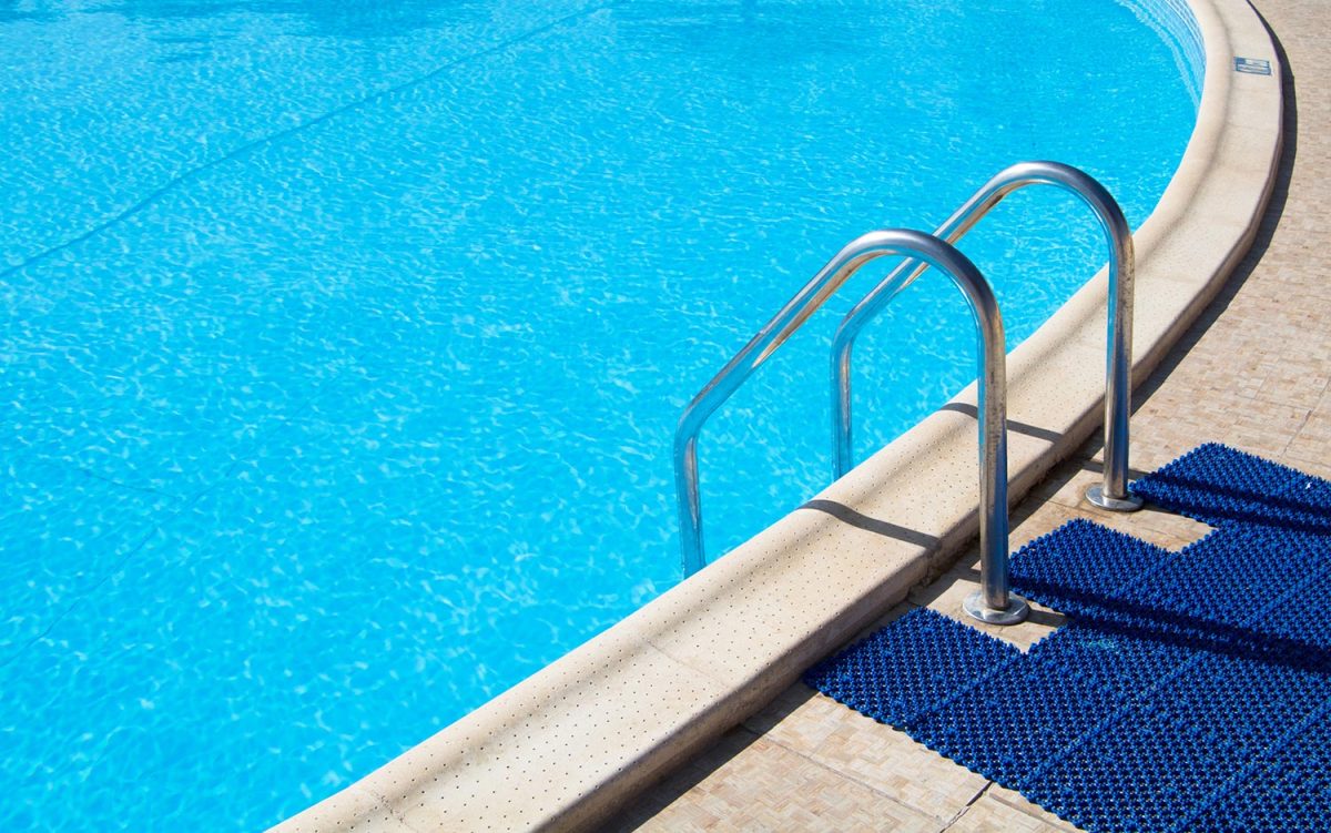 Rubber mats on an outdoor swimming pool with blue clean water