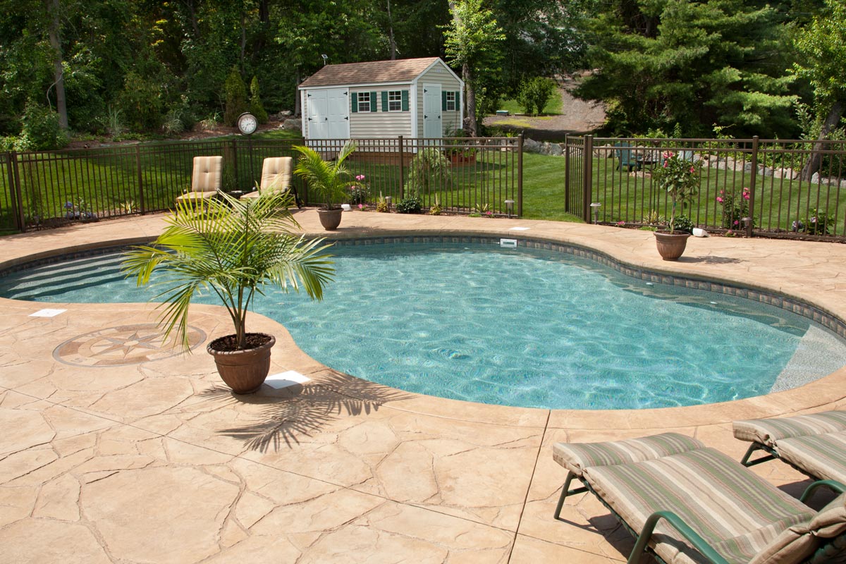 A swimming pool with flagstone stamped concrete patio, Is A Flagstone Pool Deck Hot? [And How To Prevent Heat On Your Feet]