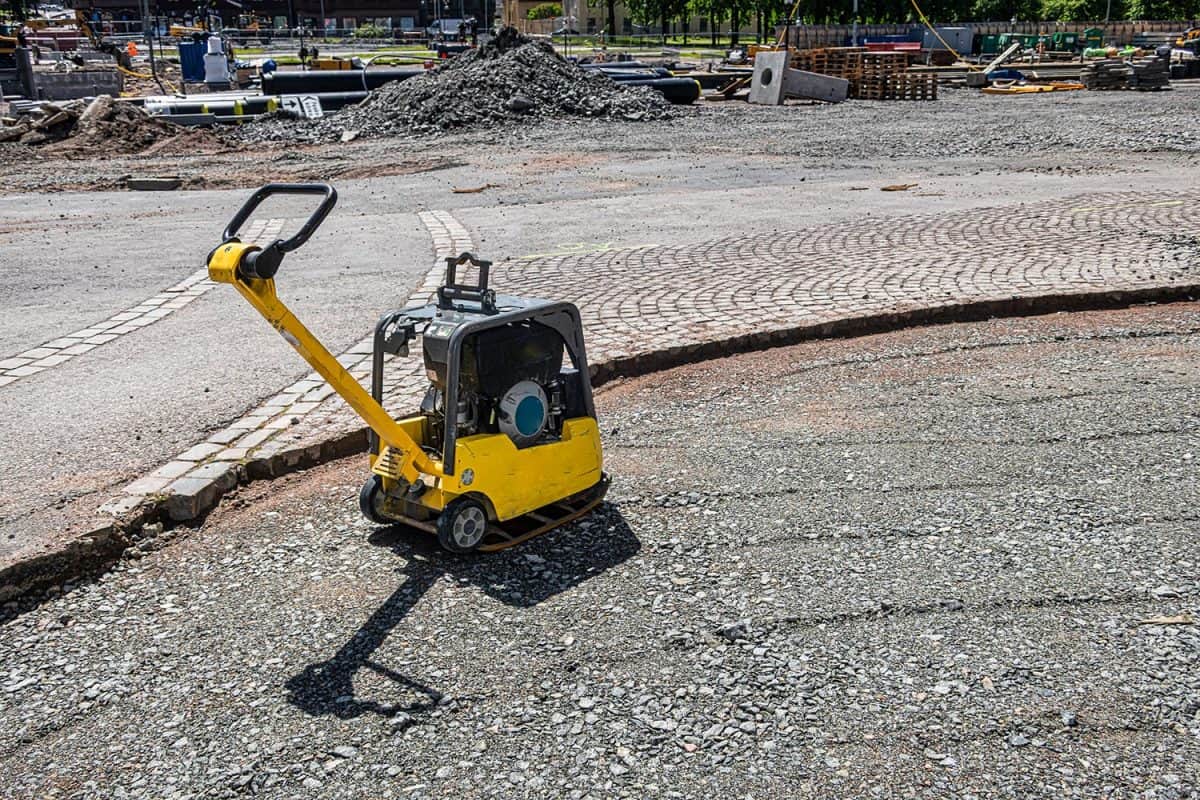 Vibratory plate compactor in a construction site