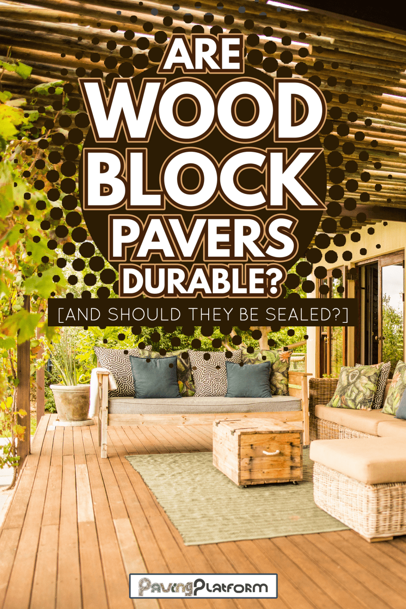 Wicker patio sofa and furniture sitting outside on a rustic wooden balcony on a sunny afternoon - Are Wood Block Pavers Durable [And Should They Be Sealed]