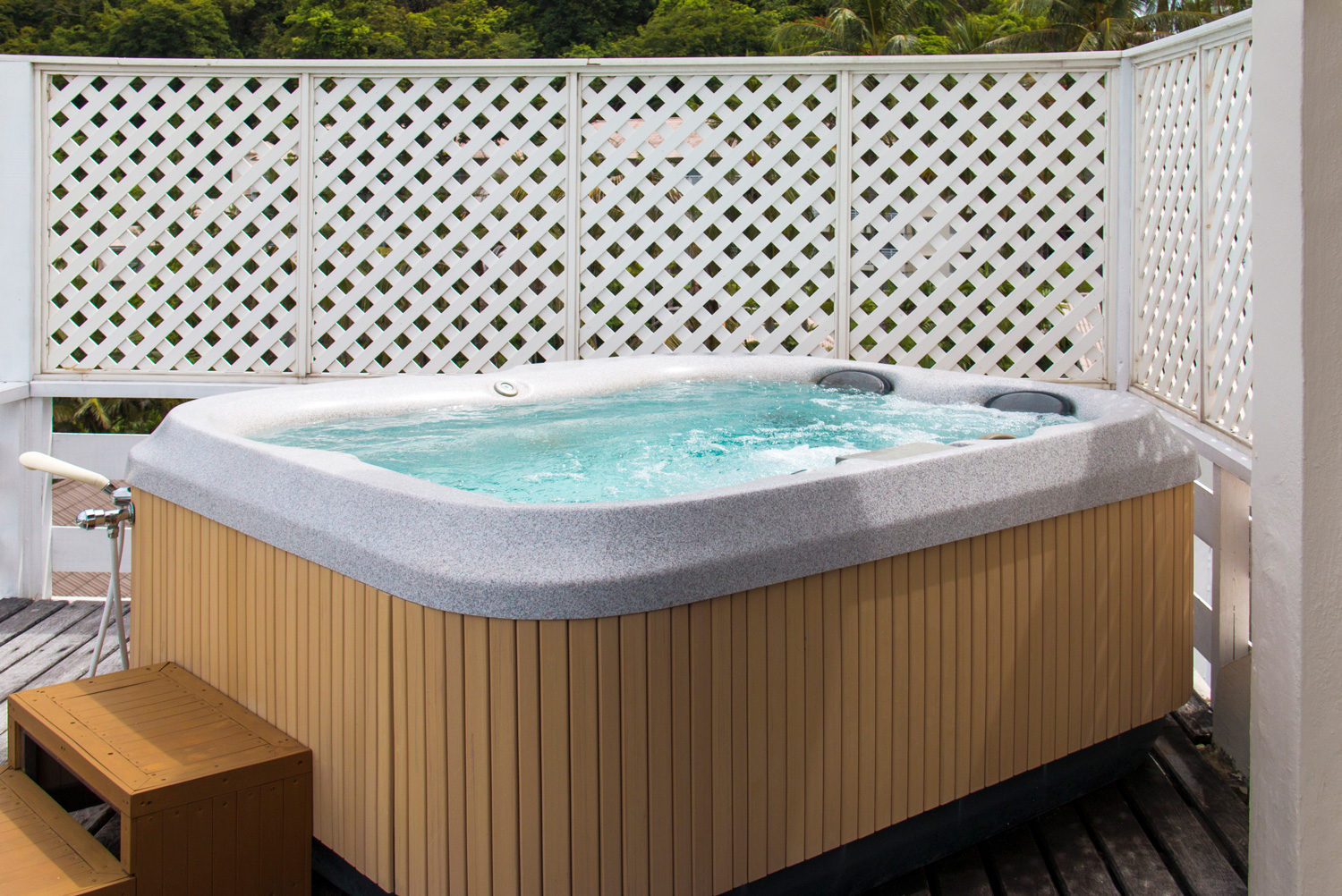 Wooden hot tub with swirling water at outdoor.