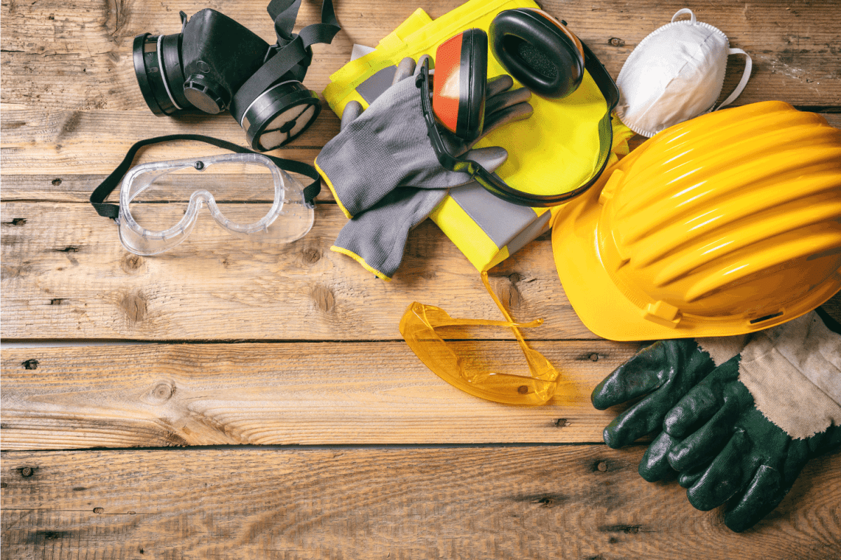 Work safety. Construction site protective equipment on wooden background