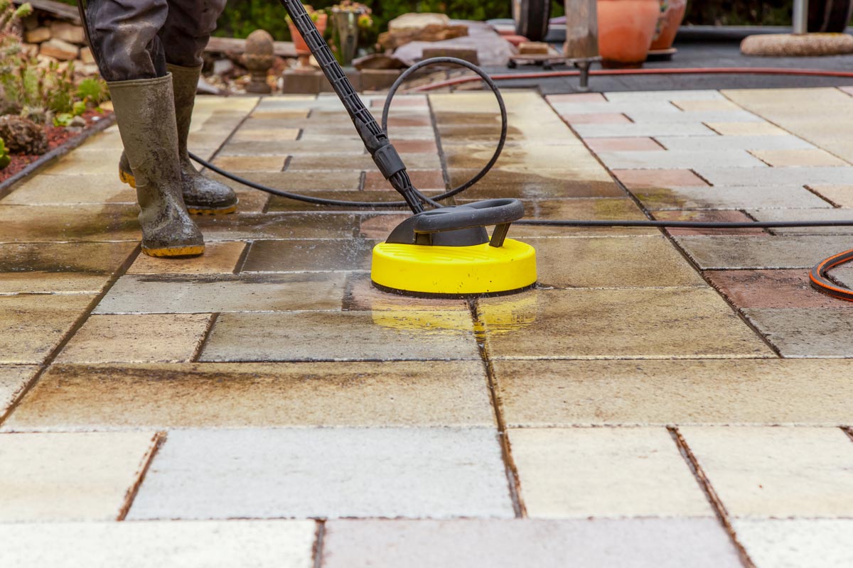 A worker cleaning the outdoors floor, Can You Clean Pavers With Bleach? [Best Cleaning Methods & Stain Removal]
