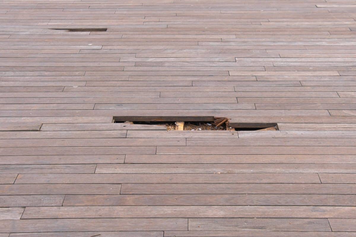 damaged and cracked hardwood flooring outdoors. old wooden floor slats.

