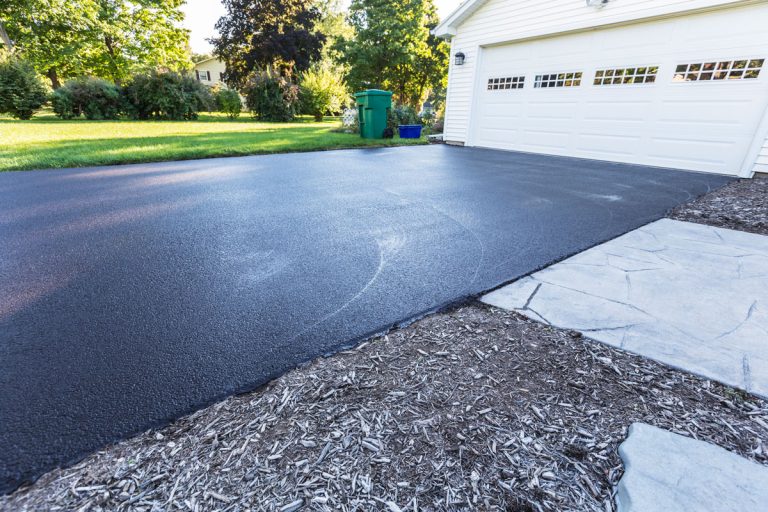 A fresh blacktop resealing job just finished on this asphalt driveway, Is Stamped Asphalt Good For Driveways? And For Patios