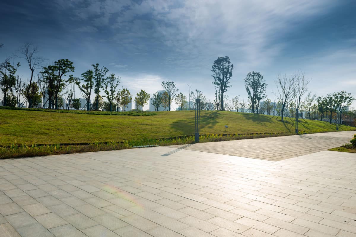 Autumn, sunny day in the woods by the lake in the park with bluestone paver, Can You Drive On Bluestone Pavers? [Pros & Cons Of Bluestone For Driveways]