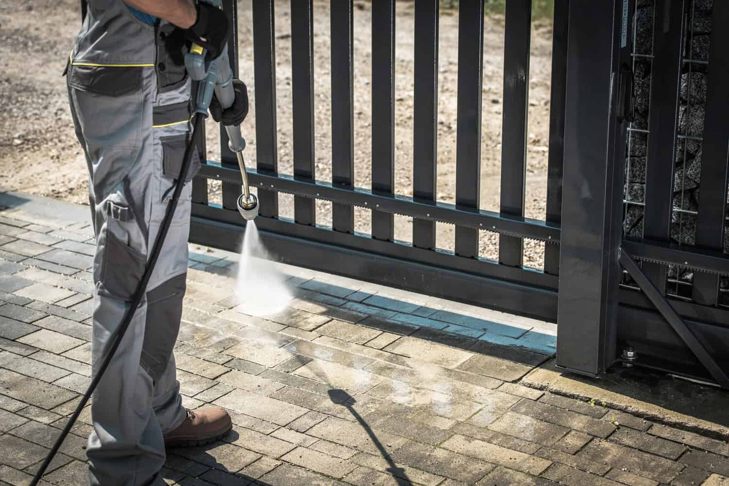 Driveway and a Gate Pressure Washing. Cleaning House Surroundings.